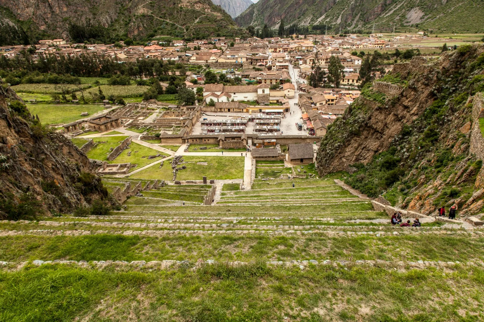 View of Ollantaytambo with mountains in the background and Inca ruins in the valley.