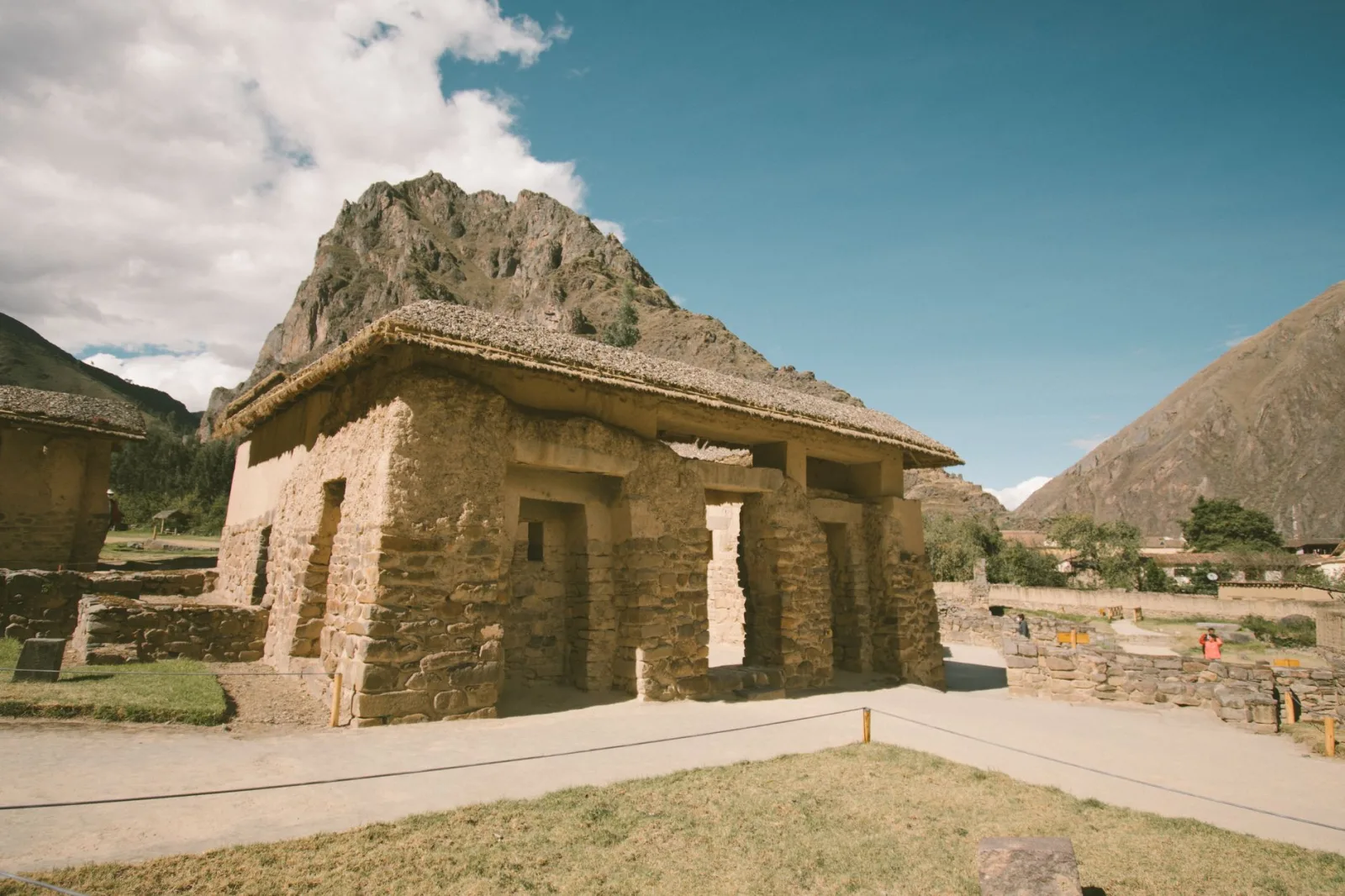 Ollantaytambo ruins with Inca terraces and stone stairway beneath the mountains.