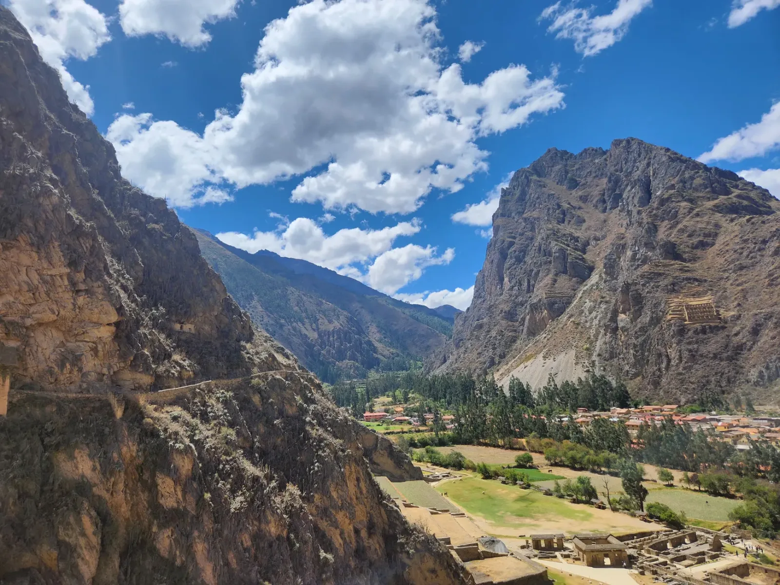 Steep trail in Ollantaytambo ascending to the Pinkuylluna granaries, with mountains in the background.