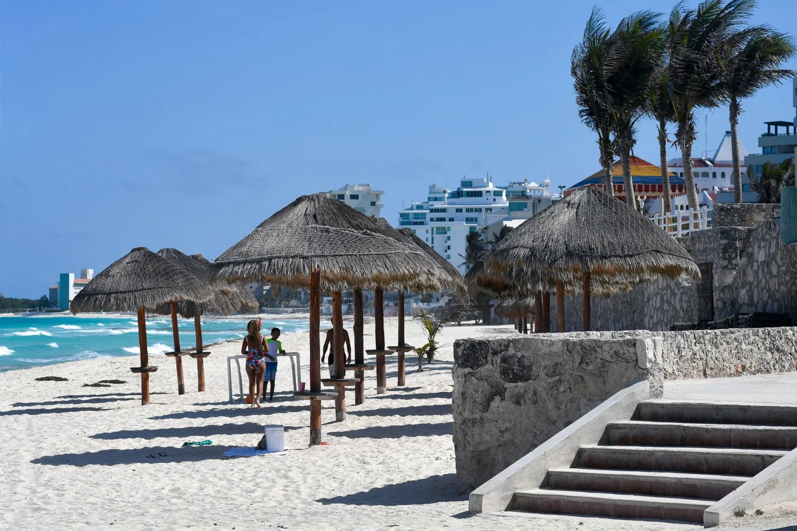 Playa de Cancún con mar azul y franja de arena clara, cercana a hoteles frente al mar