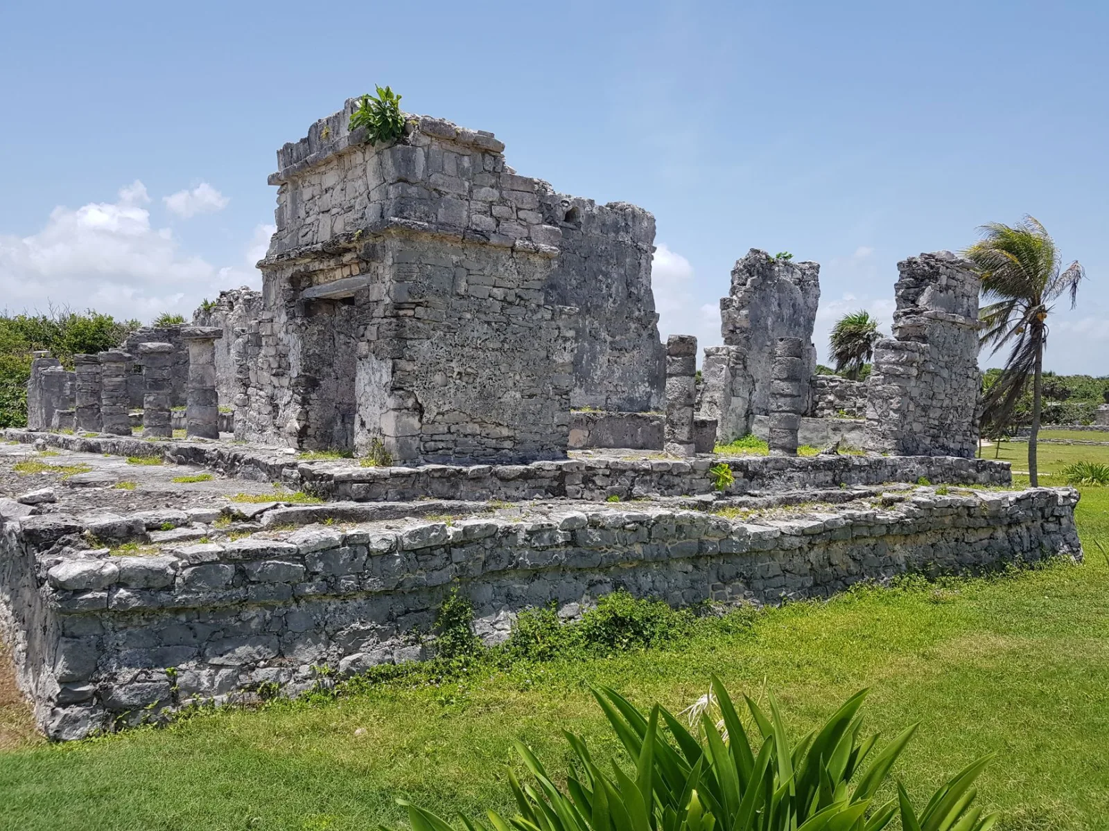 Ruinas mayas de Tulum sobre un acantilado con vista al mar azul.