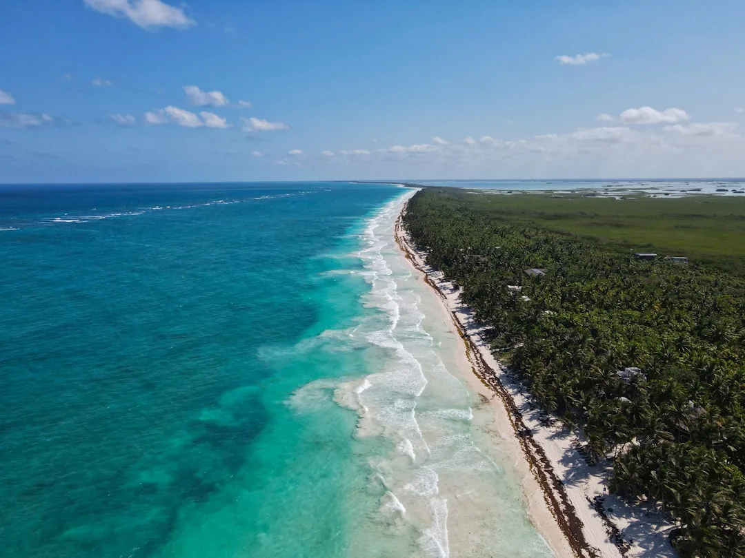 Playa de Tulum con mar turquesa, arena clara y estructura de beach club junto al mar
