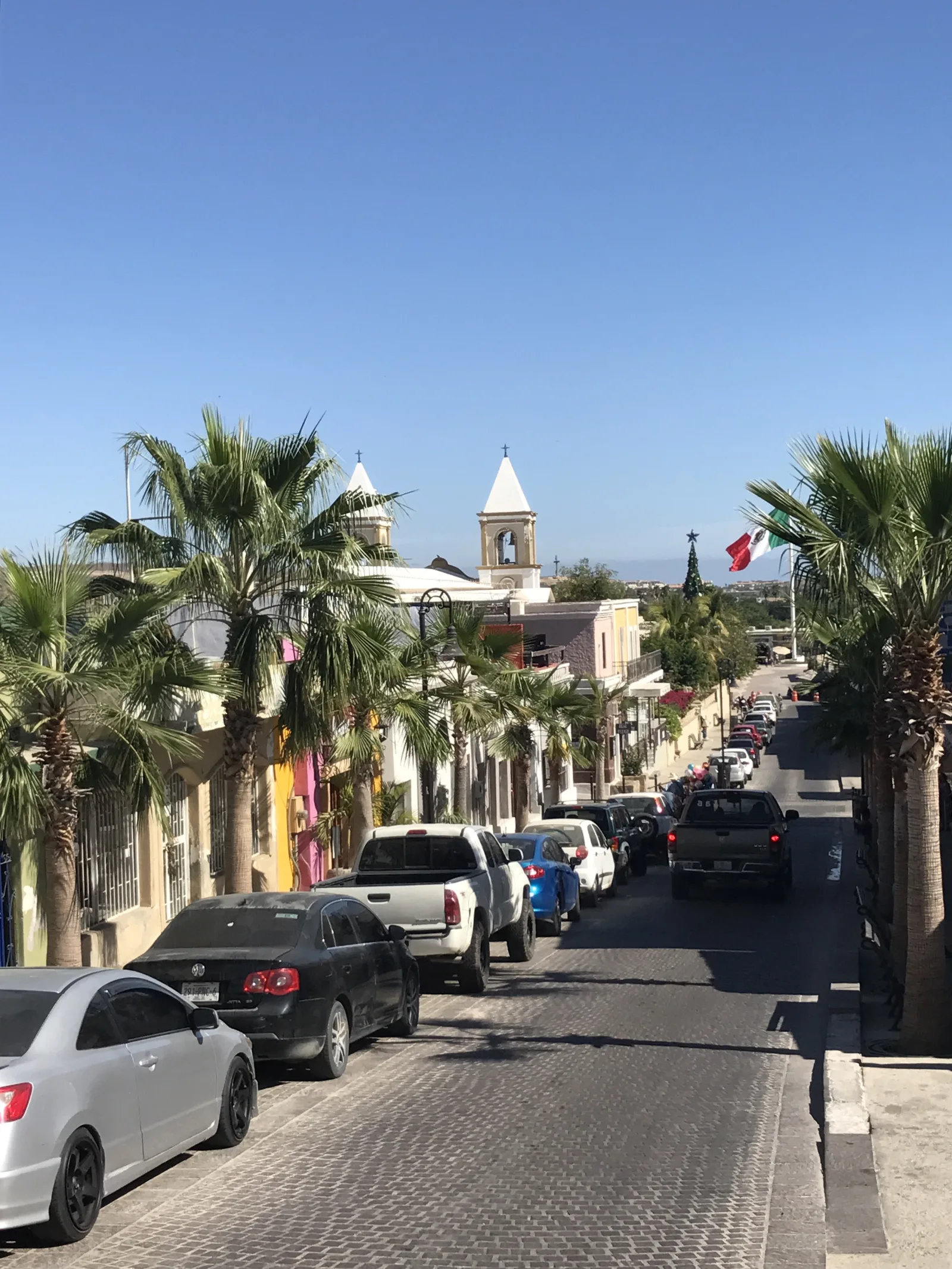 Vista del centro histórico de San José del Cabo con calles y arquitectura colonial bajo un cielo soleado.