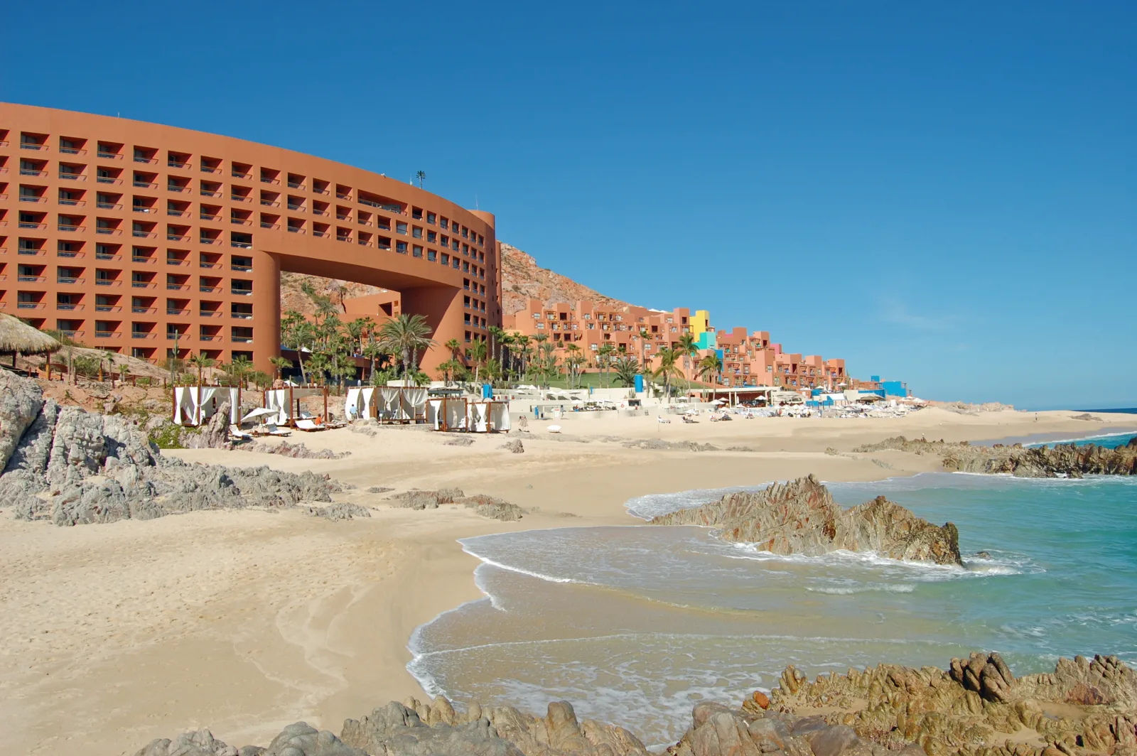 Resorts junto al mar con piscina, playa y palmeras en San José del Cabo