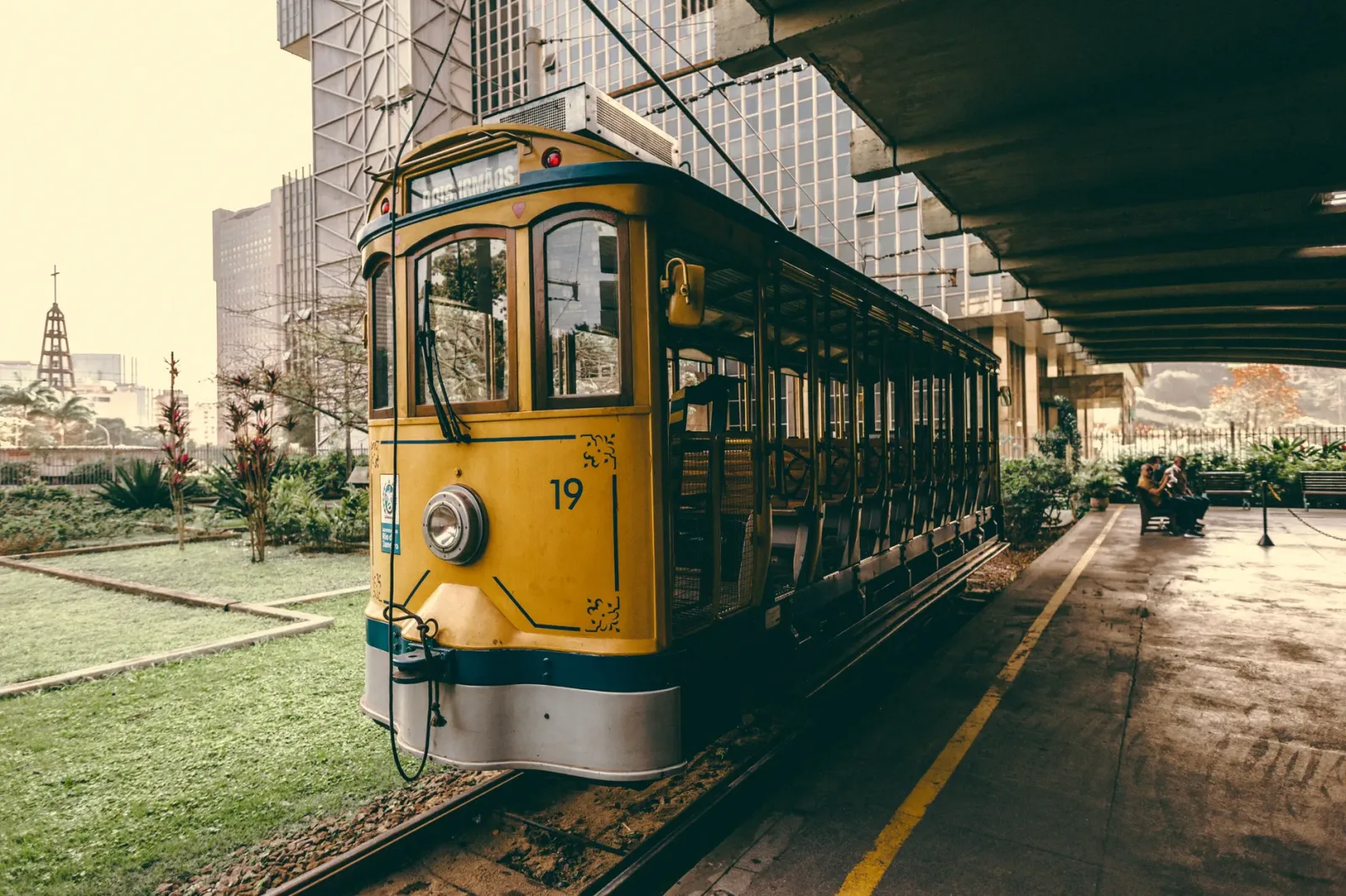 Rua do Rio de Janeiro com carros e ônibus, sugerindo opções de deslocamento urbano.