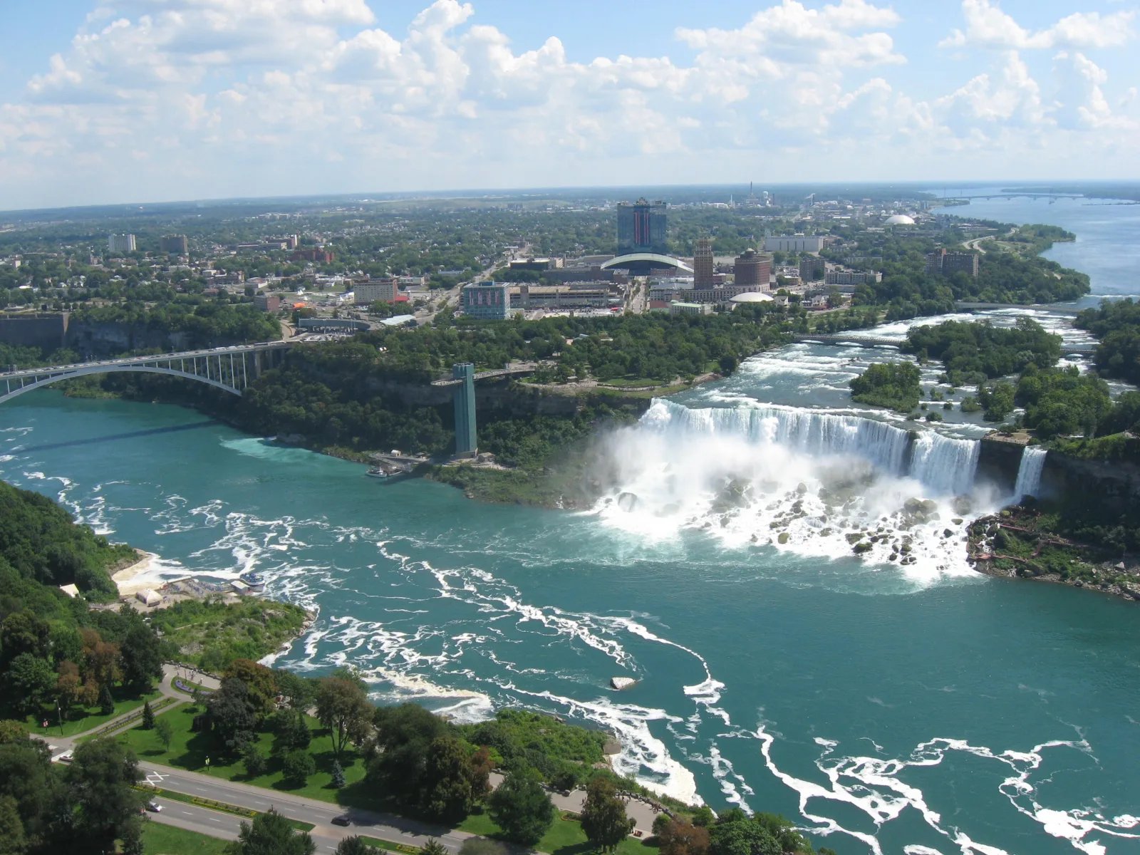 Vista panorámica de las Cataratas del Niágara, con agua cayendo y neblina sobre el río.