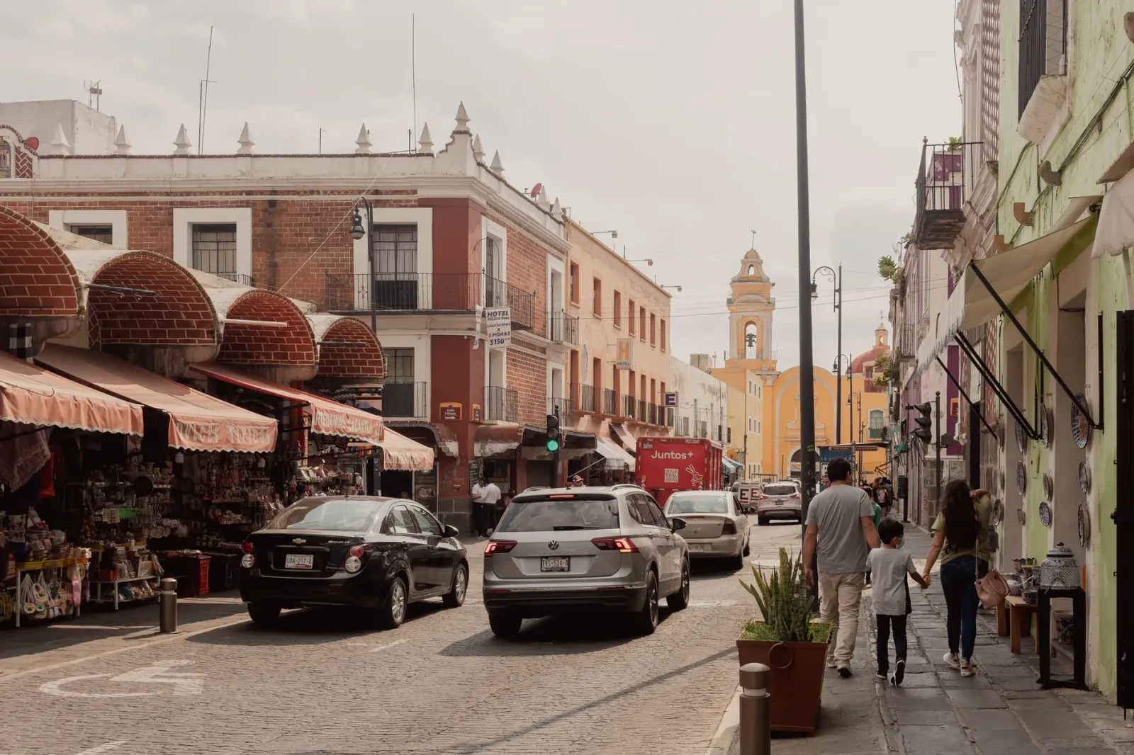 Mercado en Puebla con puestos de dulces, artesanías y productos locales coloridos.