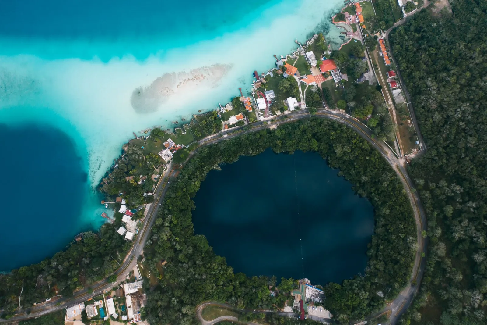 Píer público sencillo en la laguna de Bacalar, con agua azul turquesa y acceso económico.
