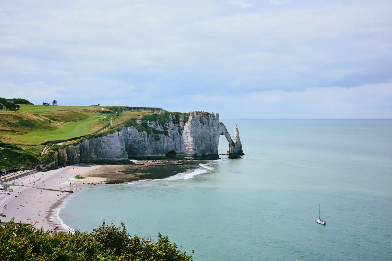 Falésias de Étretat vistas do alto, com o arco da Porte d’Aval e o mar ao fundo.