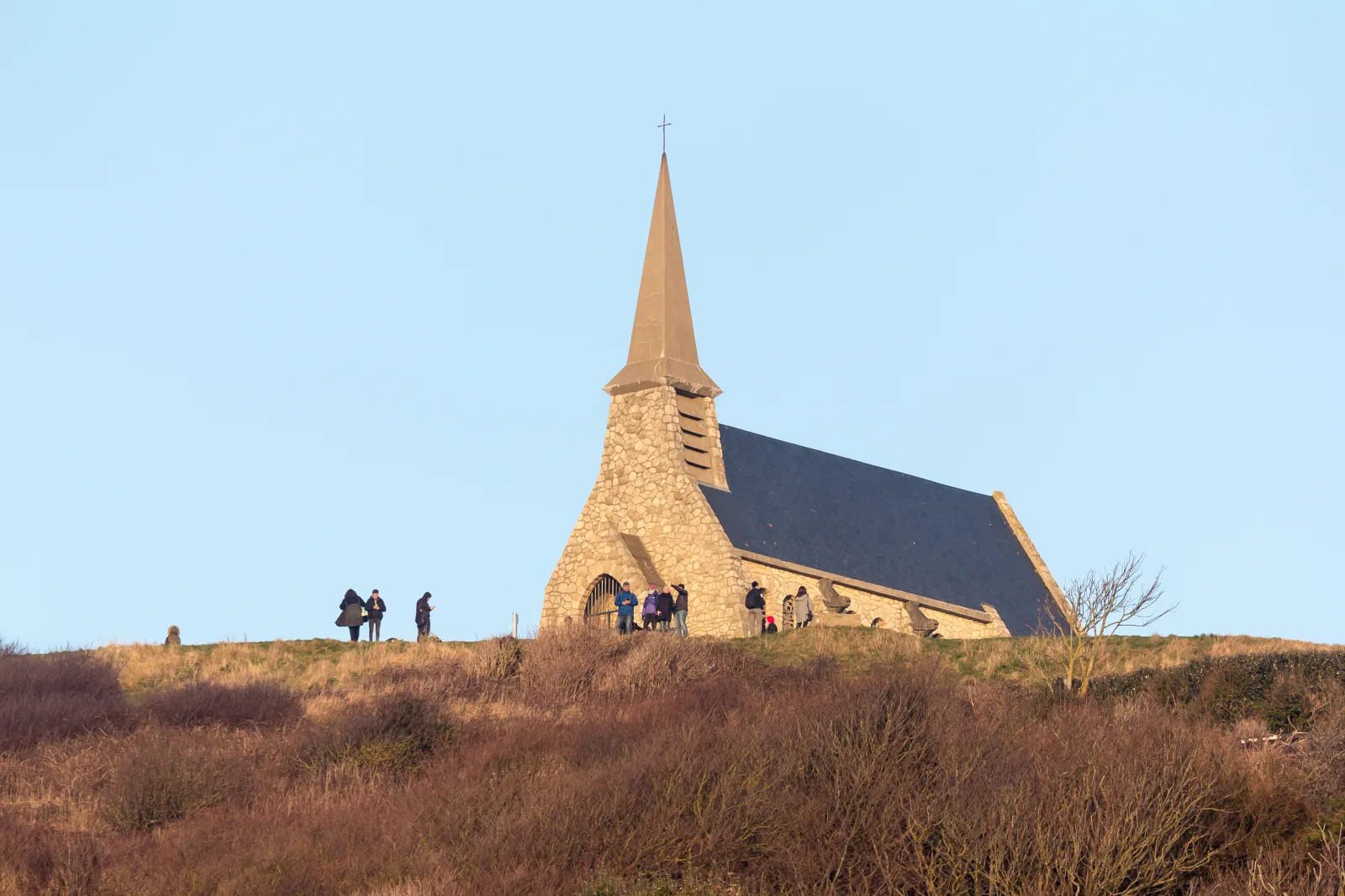 Capela de Notre Dame de la Garde no alto da falésia d’Amont, com vista de Étretat, o mar e o Porte d’Aval.