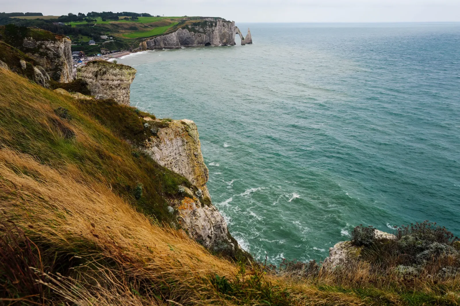 Falésias de Étretat vistas do litoral, destacando a paisagem costeira da Normandia