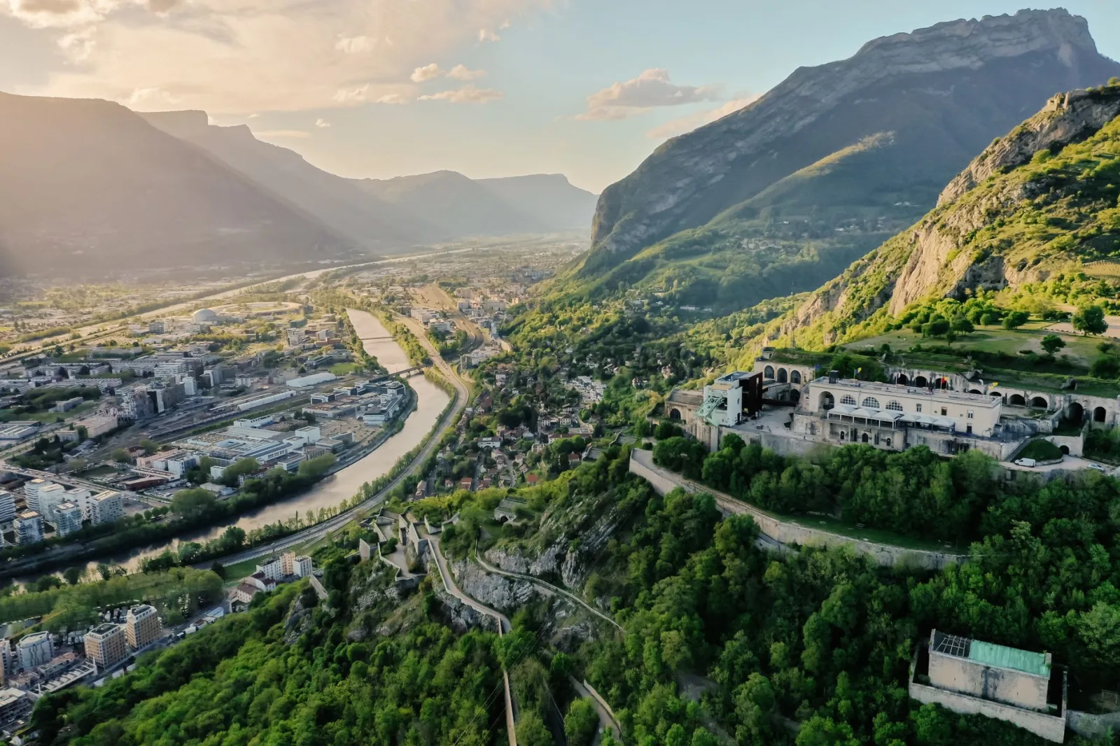 Vista de Grenoble com os Alpes ao fundo e prédios da cidade em primeiro plano