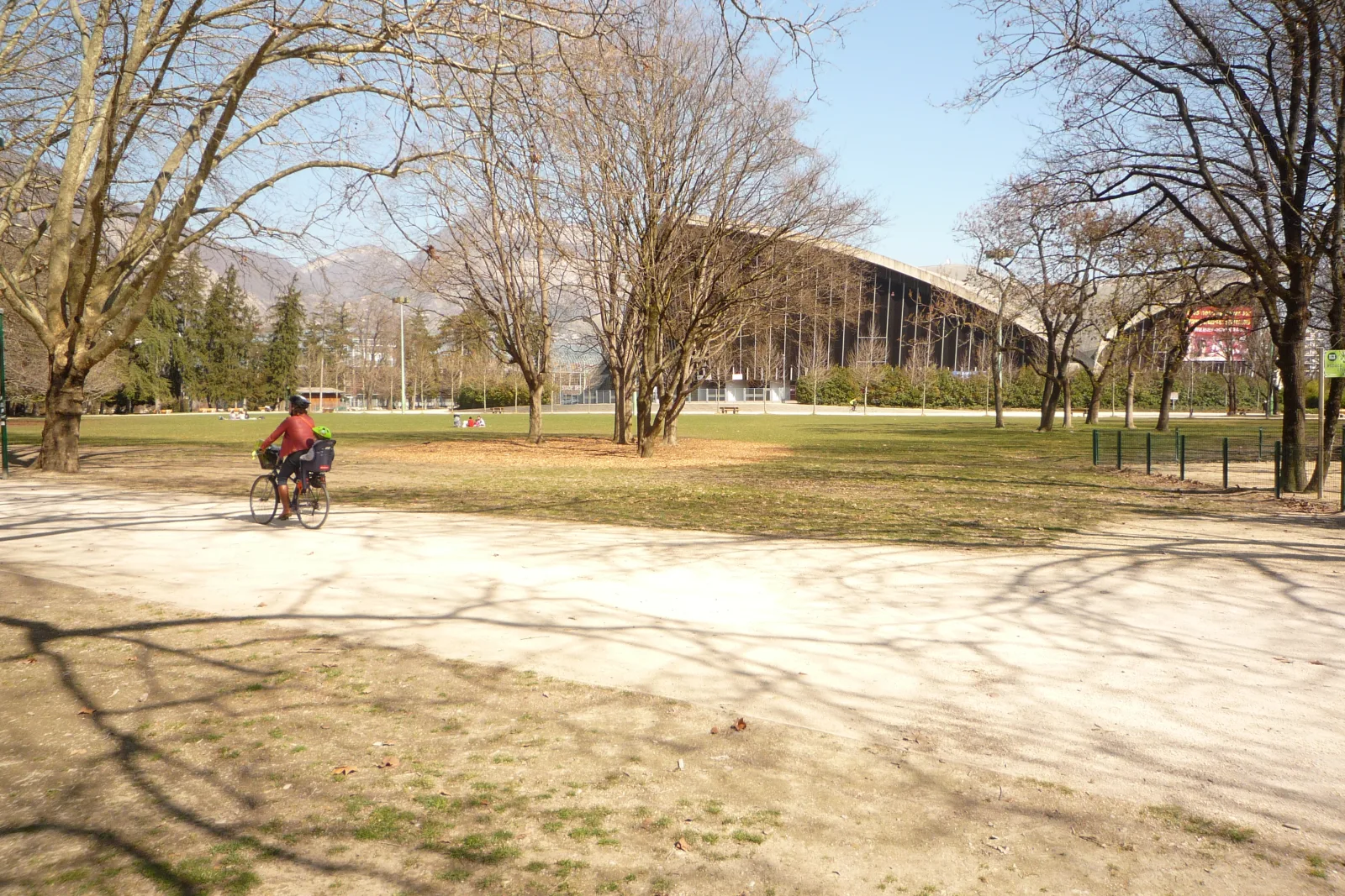 Parque arborizado de Grenoble com caminhos para caminhar, descansar e brincar ao ar livre.