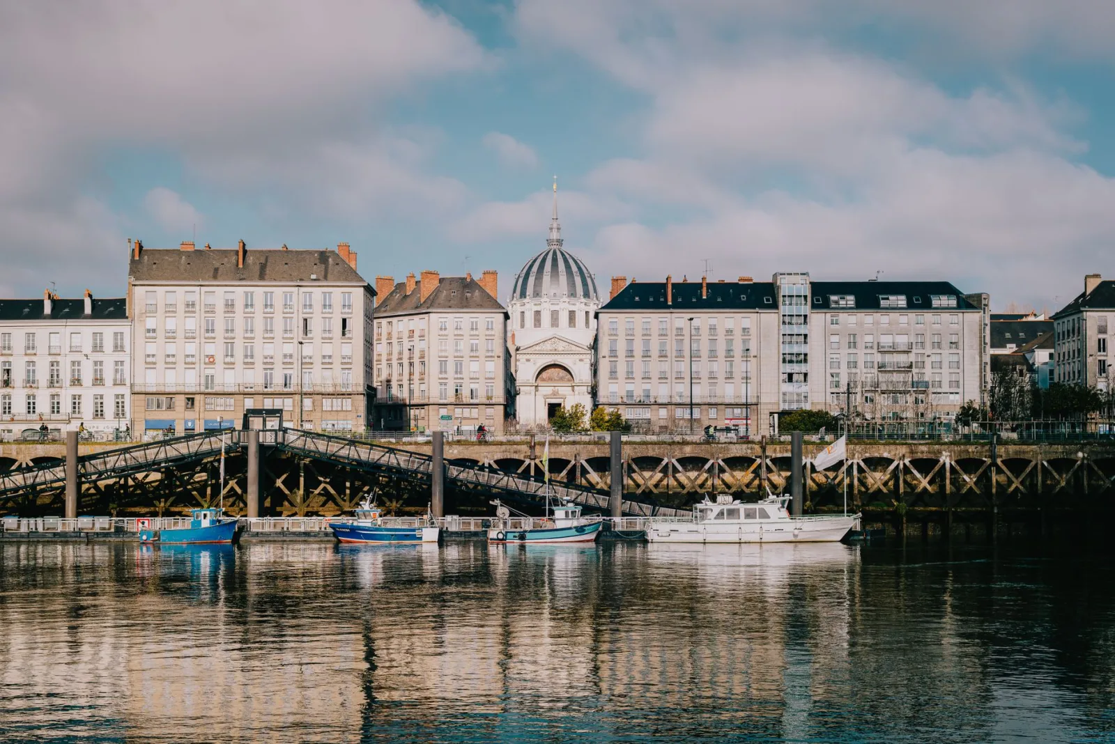 Vista urbana de Nantes a orillas del río Loira, con edificios históricos y atmósfera de gran ciudad.